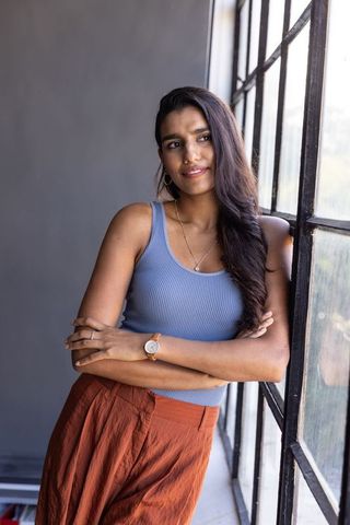 Contemplative female leaning against industrial window