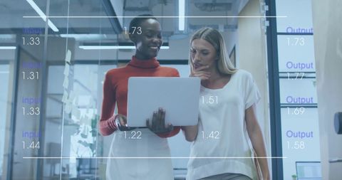 Two Professionals Analyzing Data on Laptop in Modern Office