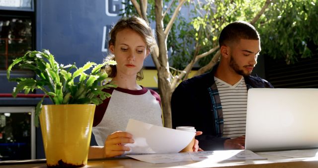 Two Young Colleagues Working on Paperwork and Laptop in Modern Office - Download Free Stock Images Pikwizard.com