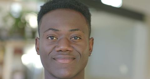 Confident african american young man smiling making eye contact closeup headshot