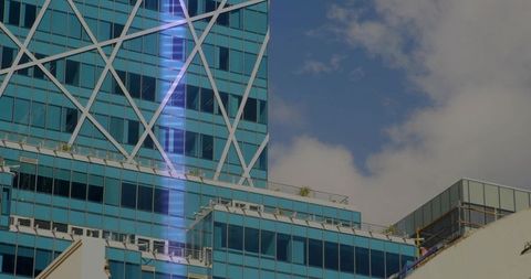 Contemporary glass tower with X-bracing, reflective curtainwall and rooftop terraces