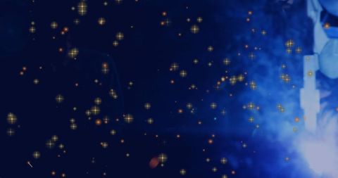 Welder Creating Bright Sparks in Dark Workshop Environment