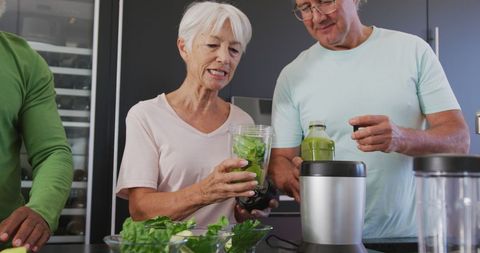 Senior Friends Preparing Healthy Smoothies in Modern Kitchen