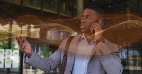 Businessman communicating on smartphone in modern glass lobby