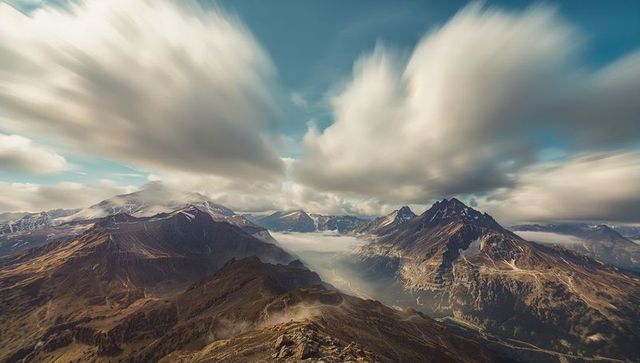 Dramatic mountain range with layered clouds and misty valleys