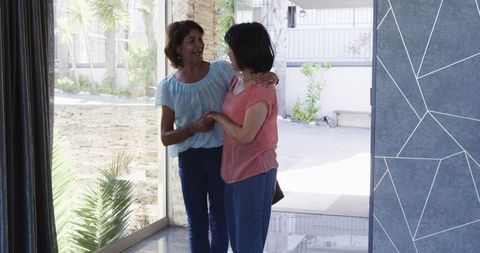 Senior Women Chatting and Laughing by Front Door