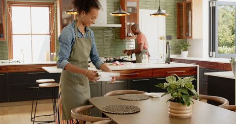 Diverse Couple Setting Table and Cooking Together at Home