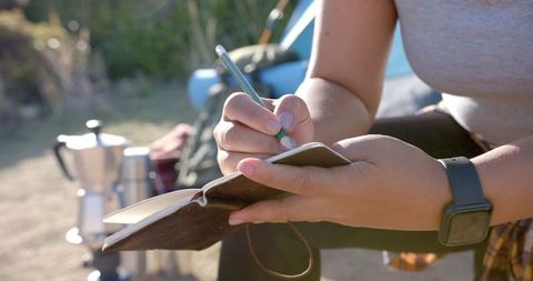 Adventurer journaling in nature during mountain expedition