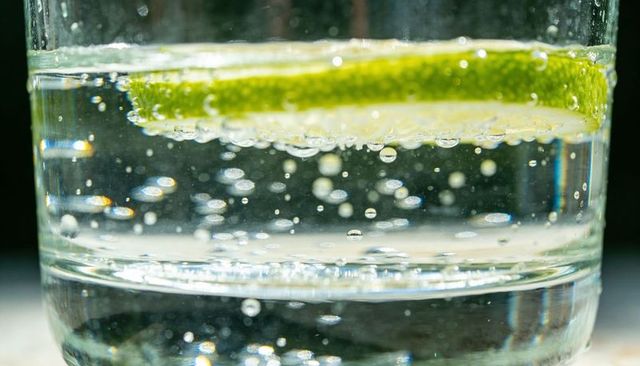 Floating lime slice in sparkling water closeup with bubbly macro detail for drink marketing