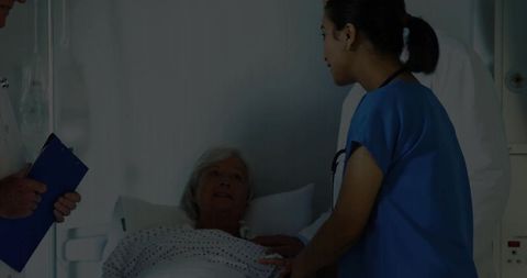 Nurse comforting senior woman in hospital bed providing compassionate bedside care