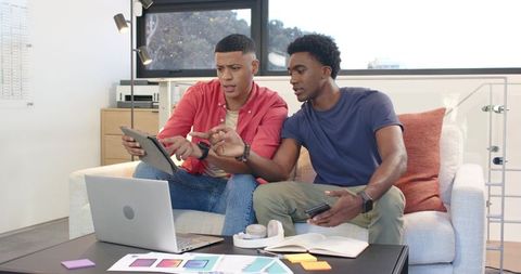 Male colleagues reviewing color swatches in modern office lounge