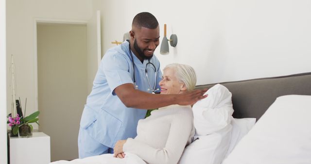 Image of happy african american male doctor supporting caucasian senior woman. seniors health and nursing home lifestyle concept.