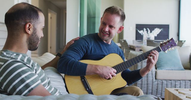 Man Playing Guitar for Friend in Living Room - Download Free Stock Images Pikwizard.com