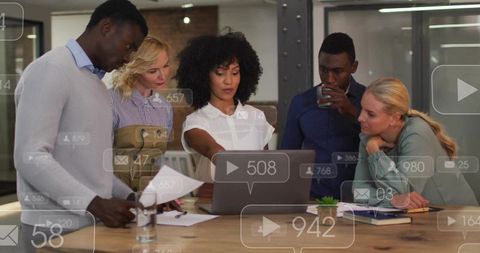 Multiracial team collaborating around laptop with social analytics overlays, woman leading