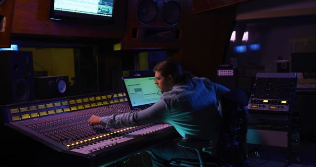 Sound engineer adjusts mixing desk and computer in studio production. - Download Free Stock Photos Pikwizard.com