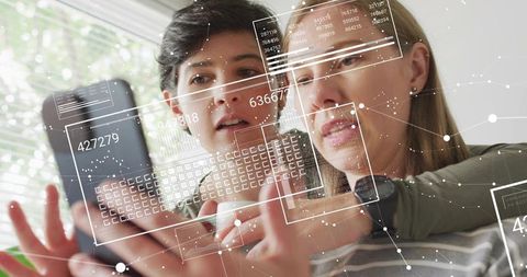 Women Collaborating on Smartphone with Augmented Reality Interface and Data Overlay