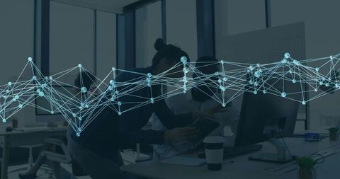 Business team collaborating over tablet and desktop with glowing network data overlay in modern offi