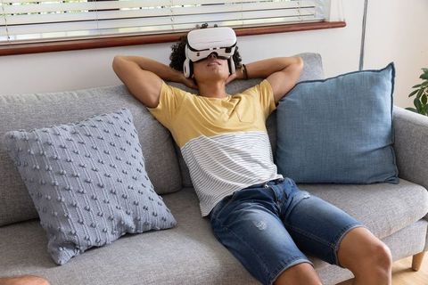 Man Relaxing with VR Headset on Comfortable Living Room Couch
