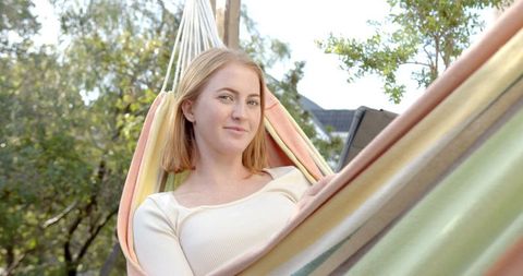 Relaxed Woman in Stripe Hammock Enjoying Outdoor Leisure