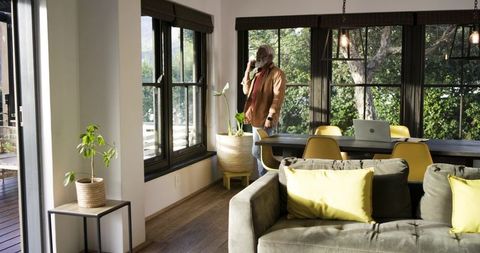 Senior man calling near windows at home office