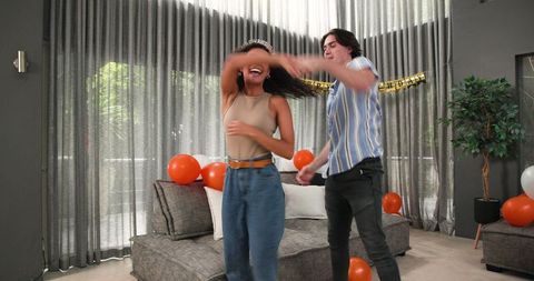 Joyful Couple Dancing at Living Room Birthday Celebration