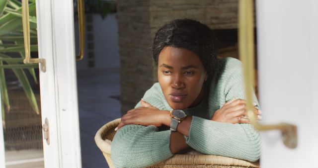 Image of sad african american woman looking outside window. lifestyle and spending free time at home.