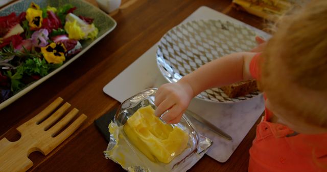 Young Child Preparing Food at Wooden Dining Table - Download Free Stock Images Pikwizard.com