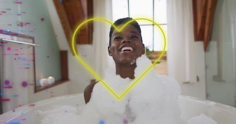 Joyful woman relaxing in foam bath with neon art