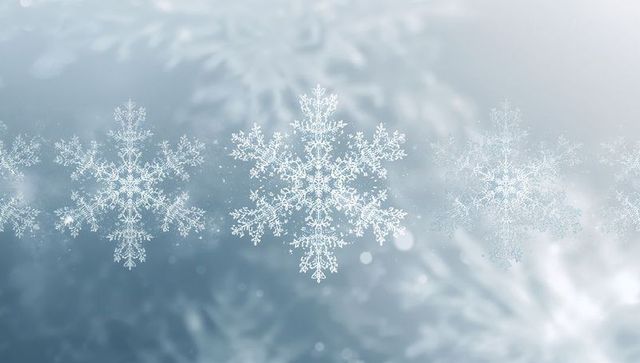 Glowing dendritic snowflake on frosted glass with soft bokeh winter background