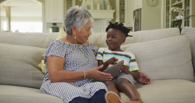 Grandmother and Grandson Sharing Tablet on Sofa at Home - Download Free Stock Images Pikwizard.com