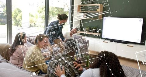 Friends lounging on sectional sofa laughing, chatting and exploring ar data overlays indoors