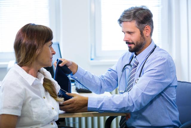 Male doctor checking blood pressure of female patient in hospital. Ideal for use in healthcare, medical, and wellness-related content. Suitable for illustrating doctor-patient interactions, medical examinations, and healthcare services.