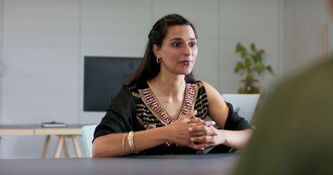 Indian businesswoman speaking confidently during interview in modern office meeting room