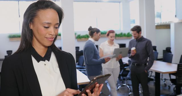 Businesswoman Using Tablet with Colleagues Collaborating in Modern Office - Download Free Stock Images Pikwizard.com