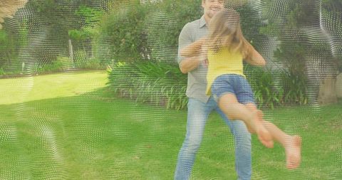 Father swinging daughter in sunny backyard with dotted mesh overlay, playful family joy