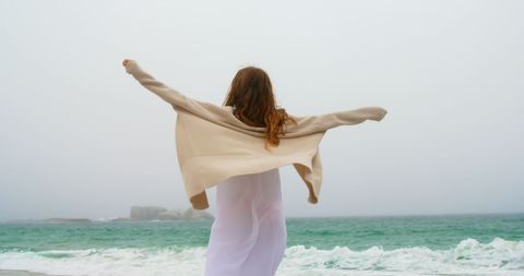 Young Woman Dancing Joyfully on Misty Beach