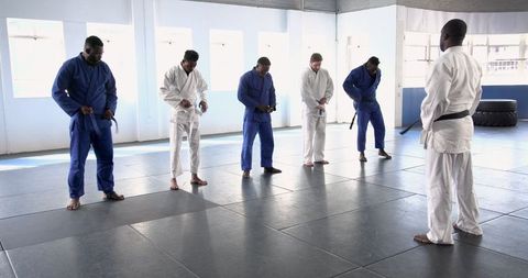 Men practicing martial arts in light-filled dojo