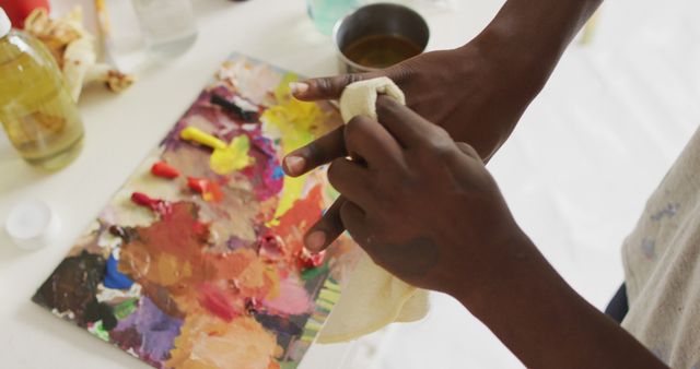 Mid section of african american male artist cleaning his hands at art studio. art, hobby and creative occupation concept