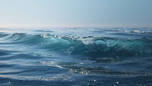 Turquoise ocean wave cresting with sunlit foam and glassy horizon closeup seascape