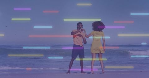 Couple dancing on beach with neon light streaks creating playful romantic connection