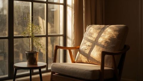 Midcentury Armchair Basking in Warm Sunlight with Window Grid Shadow and Potted Plant