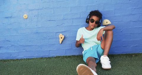 Cool African American Boy Relaxing Against a Vibrant Blue Wall