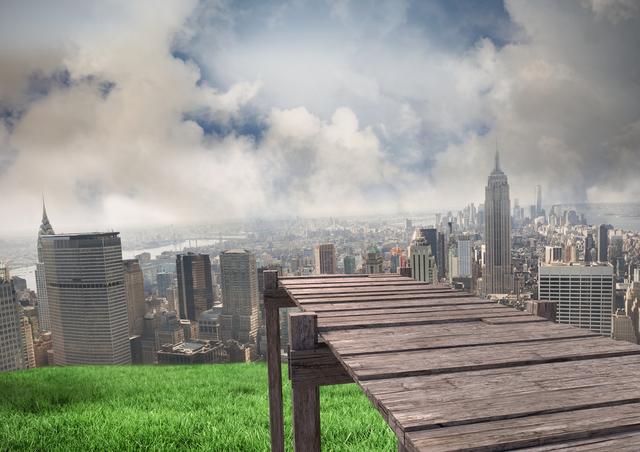 Wooden walkway extending over green grass with a panoramic view of a modern cityscape in the background. Skyscrapers rise into the cloudy sky, creating a striking contrast between nature and urban architecture. Ideal for concepts of urbanization, contrast between nature and city, and surreal landscapes.