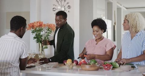 Friends joyfully preparing meal together in modern kitchen