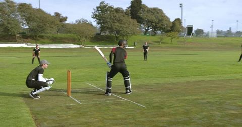 Batsman Guarding Wicket on Sunny Cricket Ground