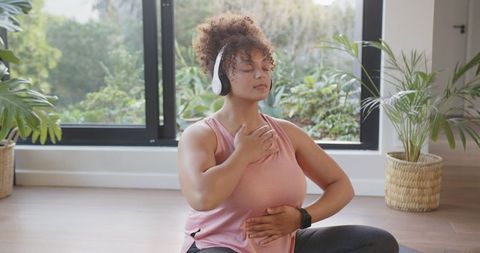 Woman Meditating at Home with Headphones and Smartwatch