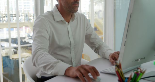 Focused Businessman Working on Desktop Computer in Modern Office - Download Free Stock Images Pikwizard.com