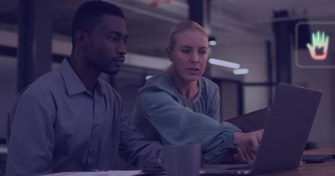 Business team collaborating over laptop in modern office pointing at visual data charts