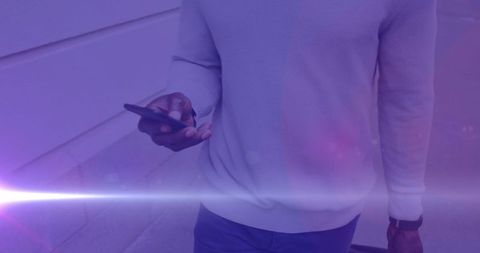 Casual Businessman Walking with Smartphone at Dusk