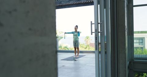 Woman Stretching with Resistance Band on Luxury Terrace